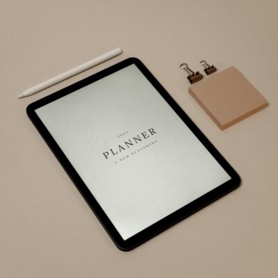 2024 digital planner displayed on a tablet with minimalistic accessories and pink background.