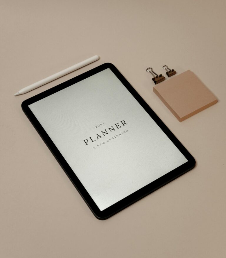 2024 digital planner displayed on a tablet with minimalistic accessories and pink background.