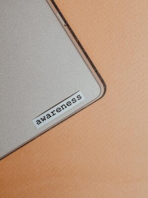 Close-up of a beige laptop with an awareness sticker, promoting mindfulness and digital organization.