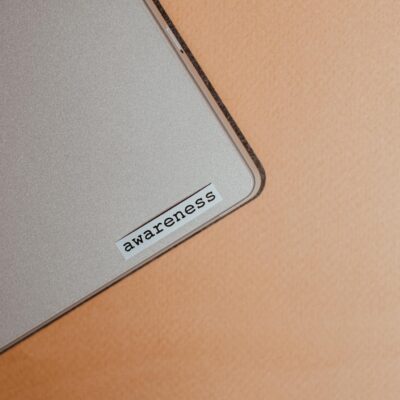 Close-up of a beige laptop with an awareness sticker, promoting mindfulness and digital organization.