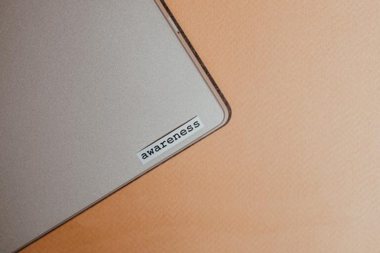 Close-up of a beige laptop with an awareness sticker, promoting mindfulness and digital organization.